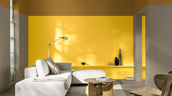 Ruang tamu dengan dinding berwarna kuning dan sofa putih